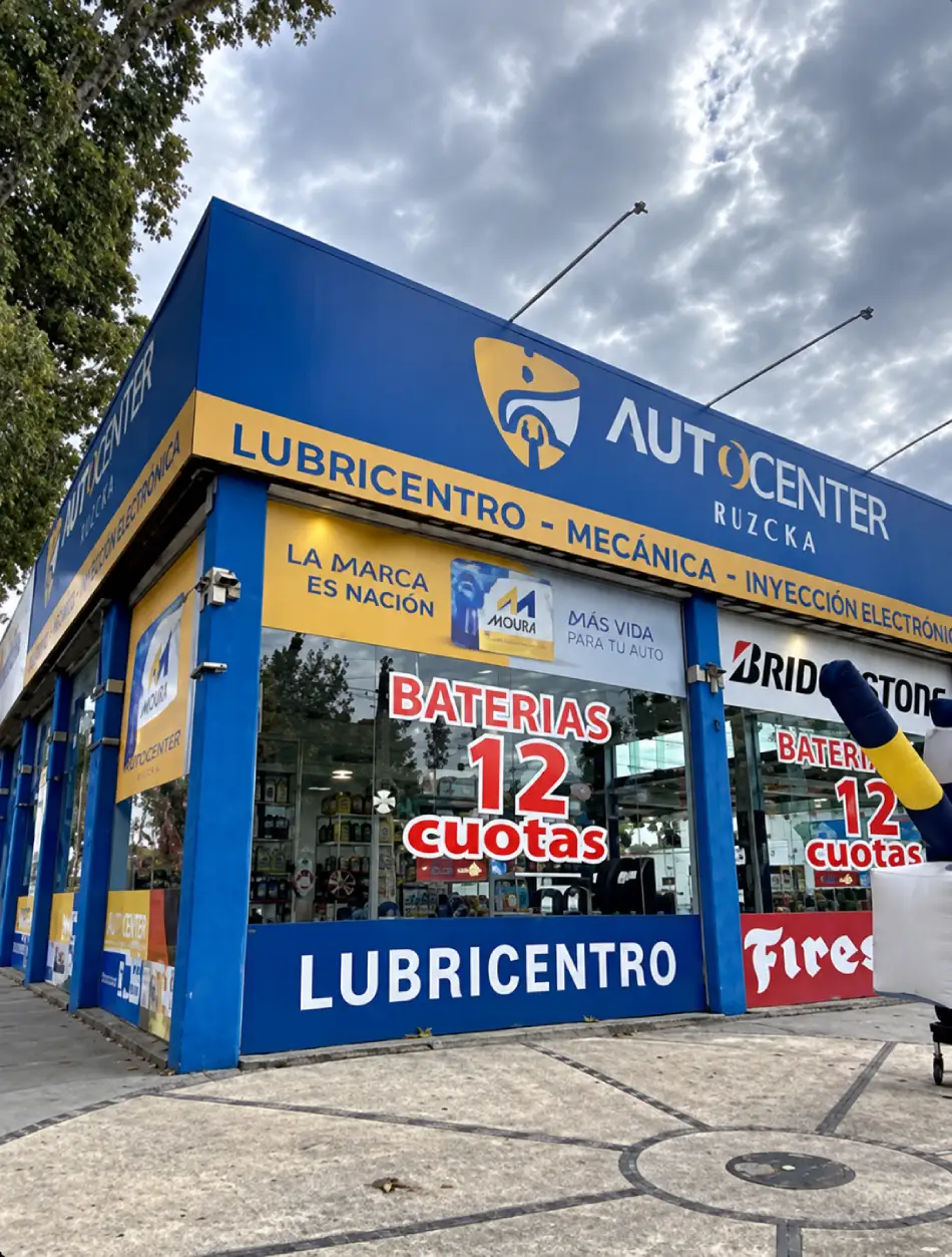Fachada de AutoCenter Rivera sobre Av. Bodereau, con el cartel azul y amarillo