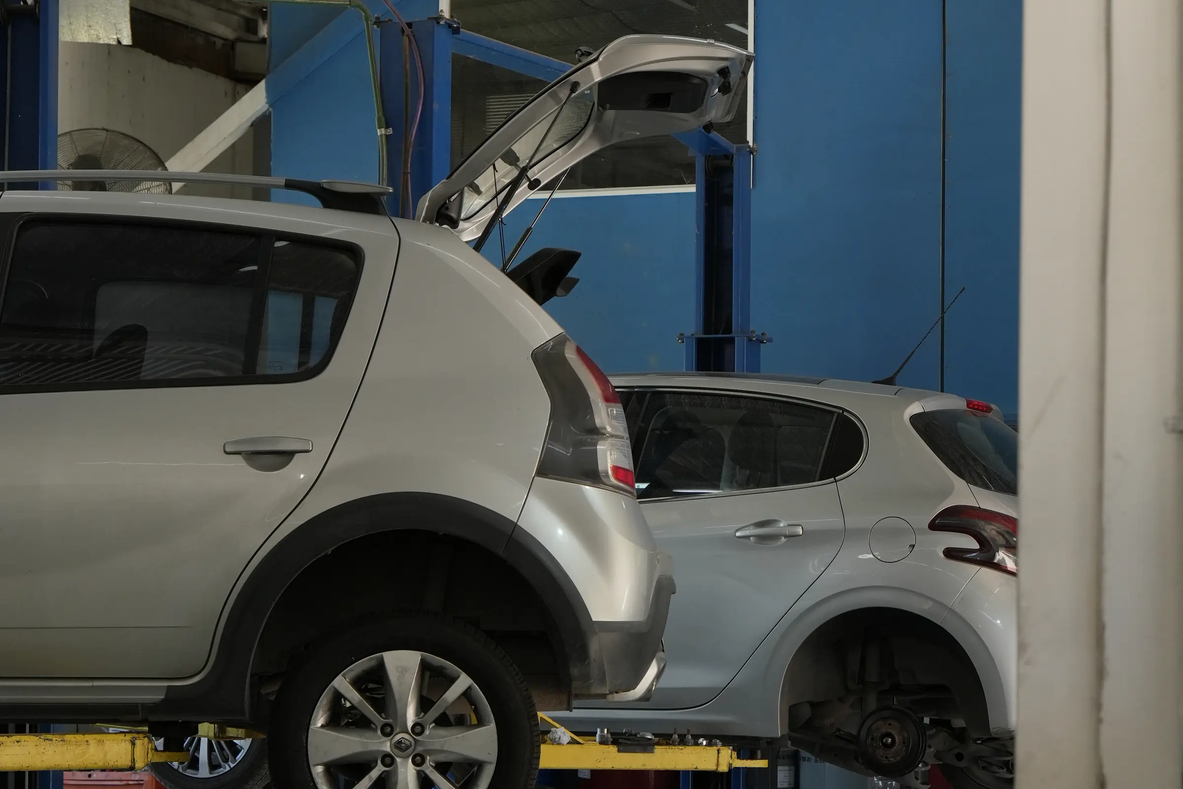 Auto con la rueda desmontada en un box del taller de AutoCenter Rivera